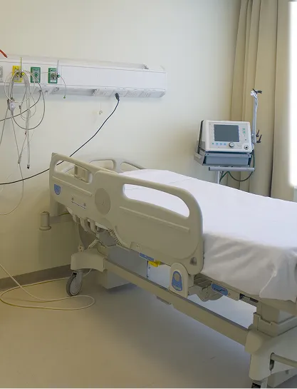 Hospital patient bed room with medical monitoring equipment.